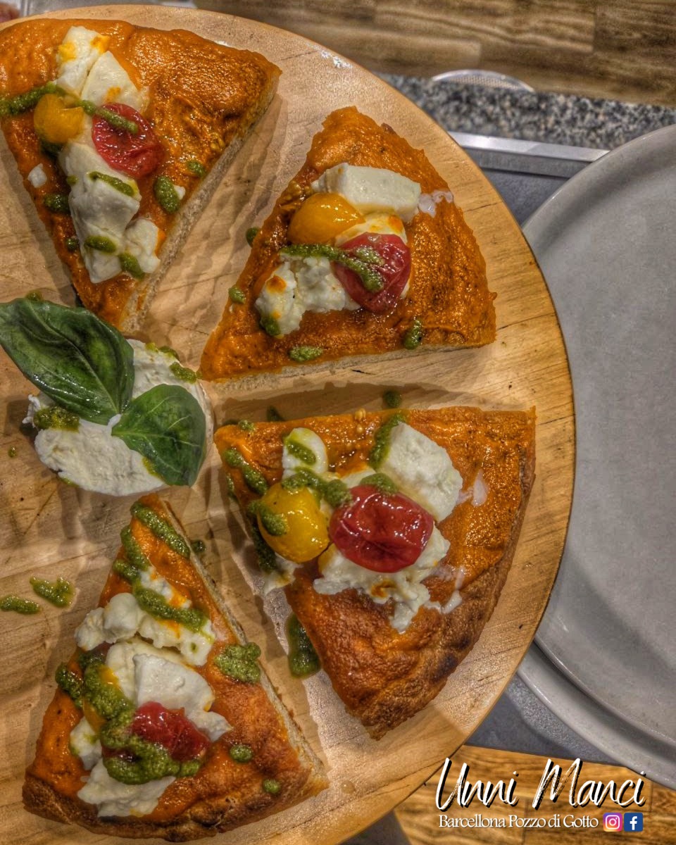 Pizza gourmet a spicchi con pomodorini, burrata e pesto su tagliere di legno